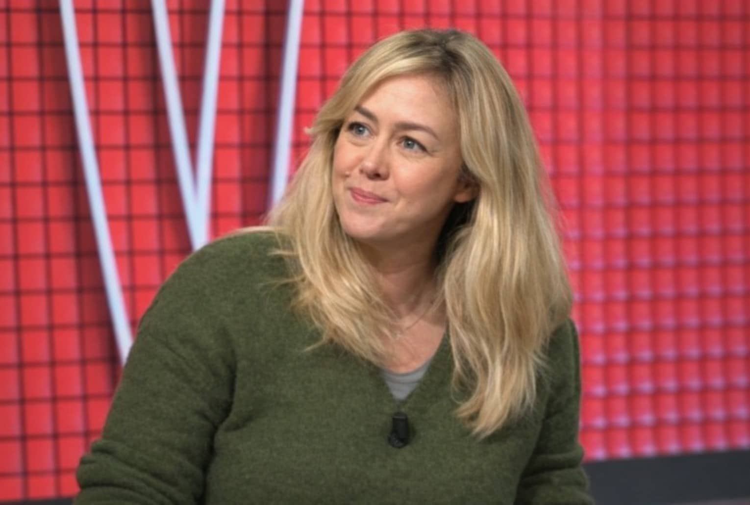 Énora Malagré sur le plateau de Buzz TV, face à un décor rouge