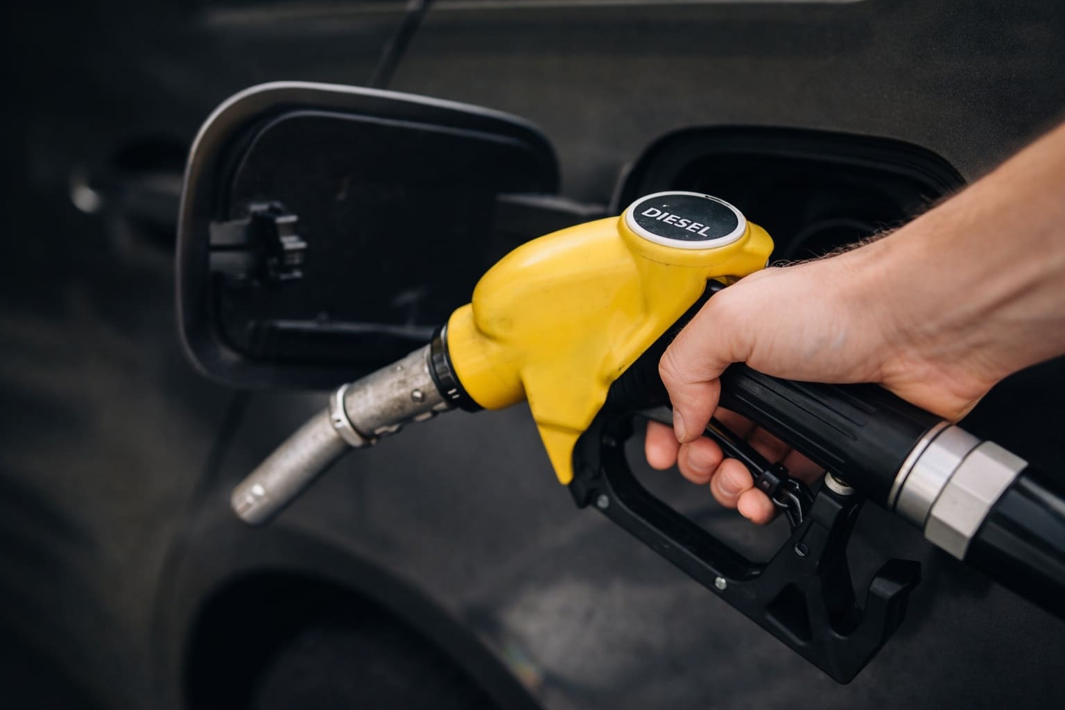 Main faisant le plein de gazole en station-service