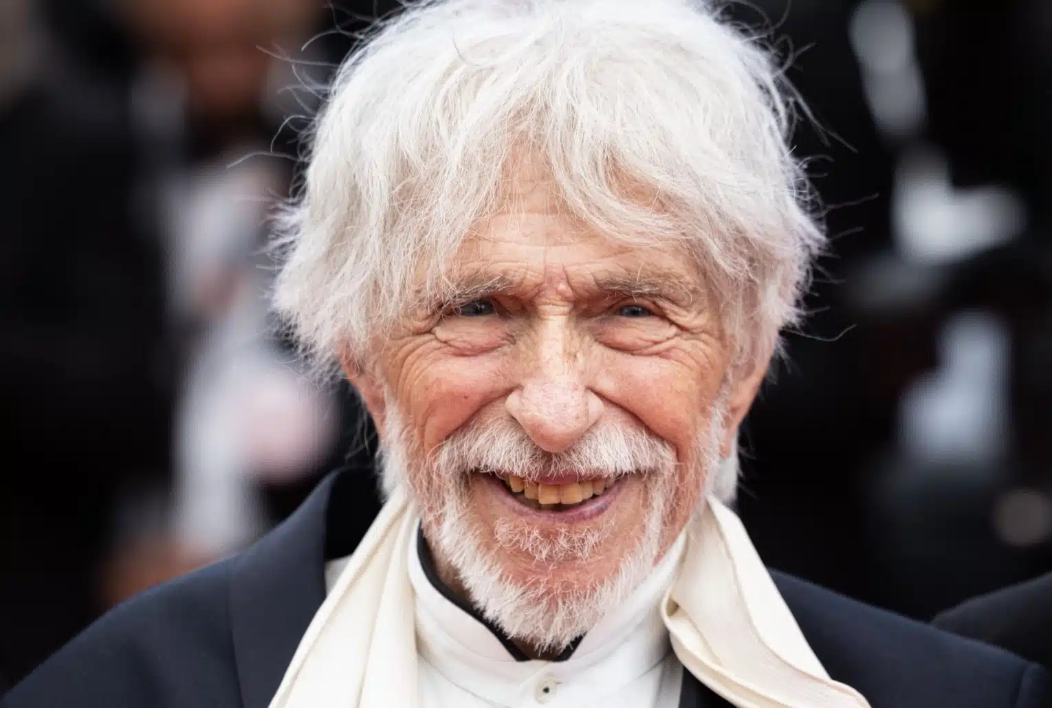 Pierre Richard souriant sur tapis rouge, portrait officiel au format paysage