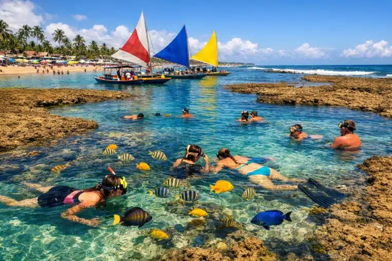 Piscines naturelles de Porto de Galinhas au Brésil, avec eau turquoise, poissons tropicaux et jangadas traditionnelles