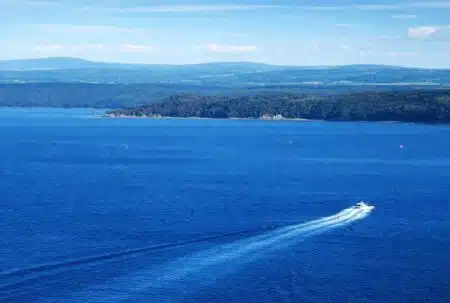 Bateau sur la rade de Brest face aux collines bretonnes, dans un paysage maritime aux airs de fjord