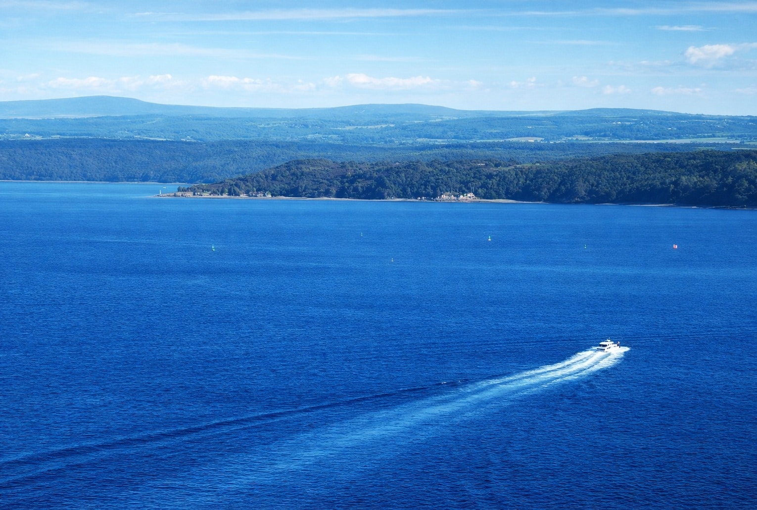 Bateau sur la rade de Brest face aux collines bretonnes, dans un paysage maritime aux airs de fjord