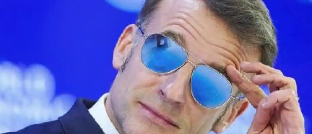 Emmanuel Macron ajustant ses lunettes de soleil bleues lors d'un événement officiel