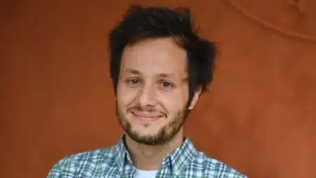 Vianney souriant lors d'une apparition publique, chemise à carreaux verts