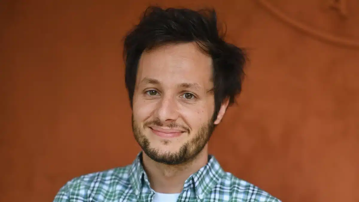Vianney souriant lors d'une apparition publique, chemise à carreaux verts