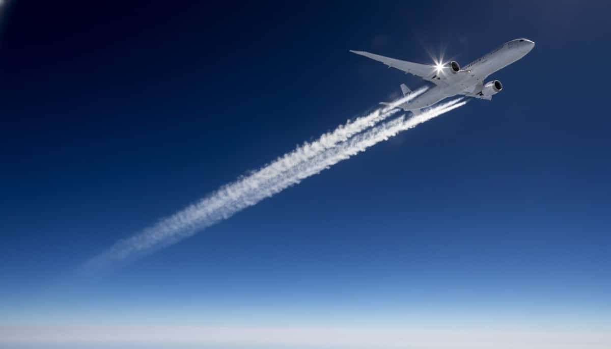 Avion laissant une traînée blanche dans le ciel bleu