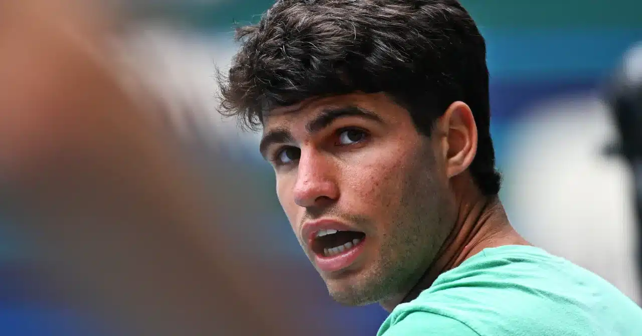 Carlos Alcaraz avec une expression concentrée et intriguée, gros plan sur son visage