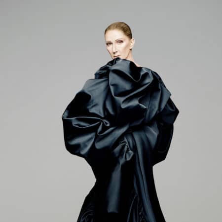 Céline Dion en robe noire volumineuse, regard intense vers l'objectif