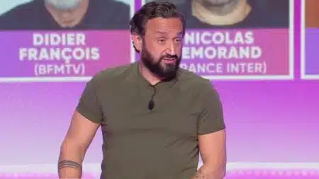 Cyril Hanouna sur le plateau de TPMP, regard caméra, fond violet avec noms de journalistes