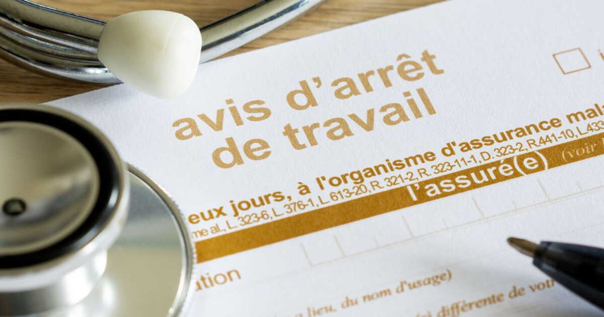 Formulaire d'avis d'arrêt de travail avec stéthoscope et stylo posés dessus