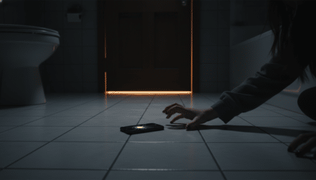 Téléphone posé au sol dans une salle de bains la nuit