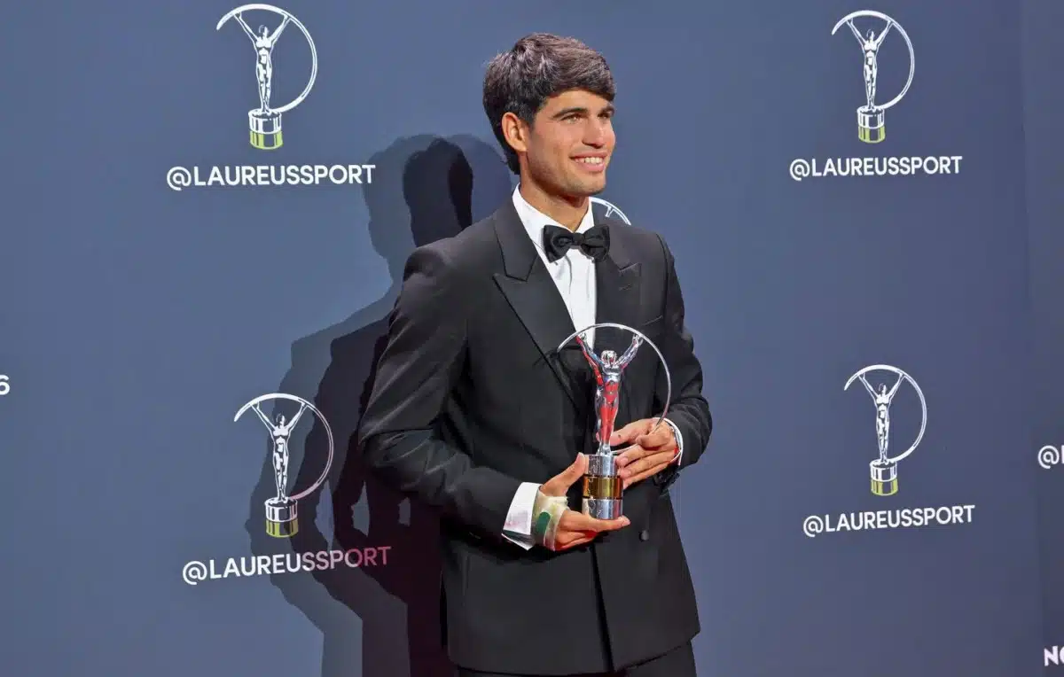 Carlos Alcaraz souriant en costume noir avec nœud papillon tenant son trophée Laureus Sport Awards