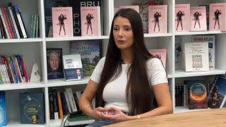 Emma Paris lors d'une interview dans une librairie, entourée d'exemplaires de son livre La Source publié chez Flammarion