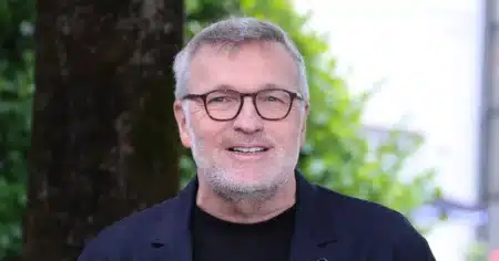 Laurent Ruquier souriant lors d'une conférence de presse, lunettes à montures écaille et veste sombre