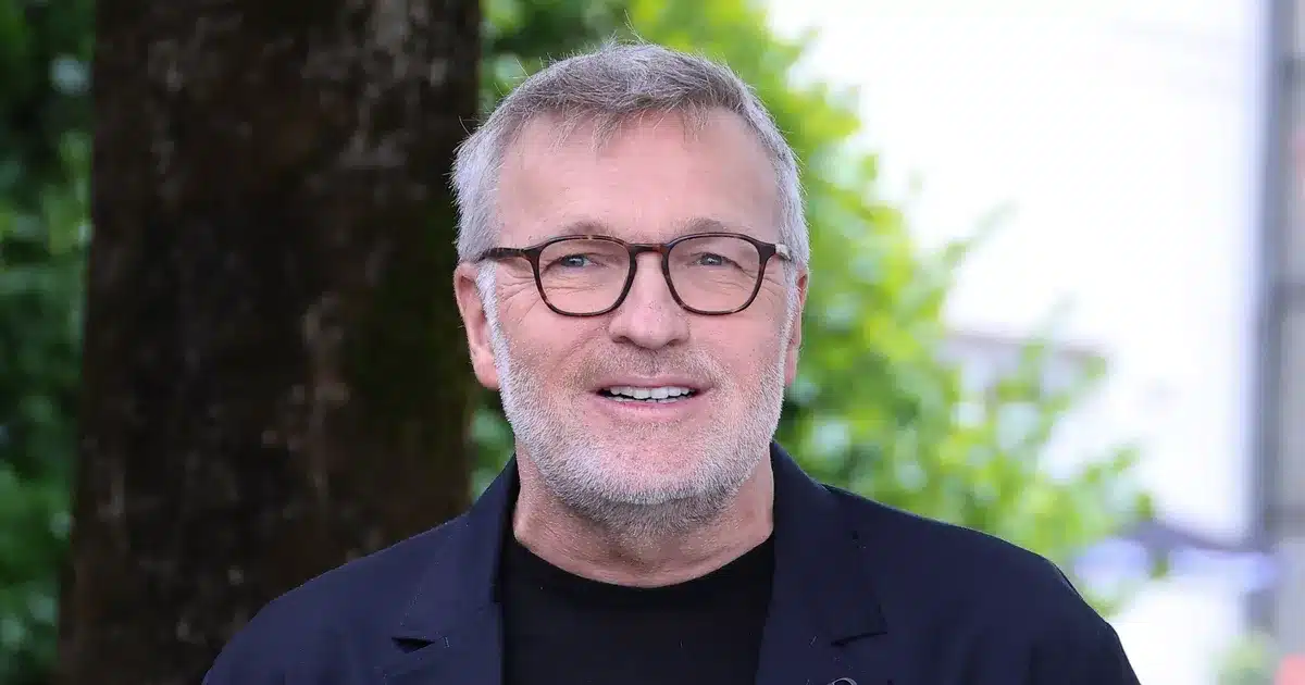 Laurent Ruquier souriant lors d'une conférence de presse, lunettes à montures écaille et veste sombre