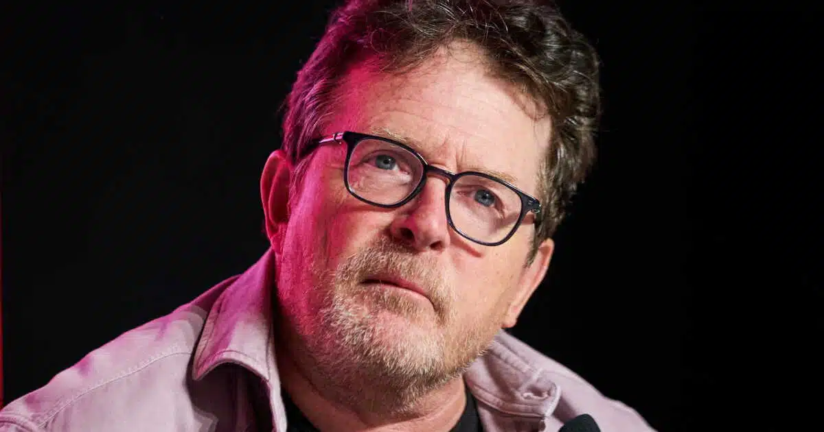 Michael J. Fox en gros plan, regard pensif, sous un éclairage rose et violet