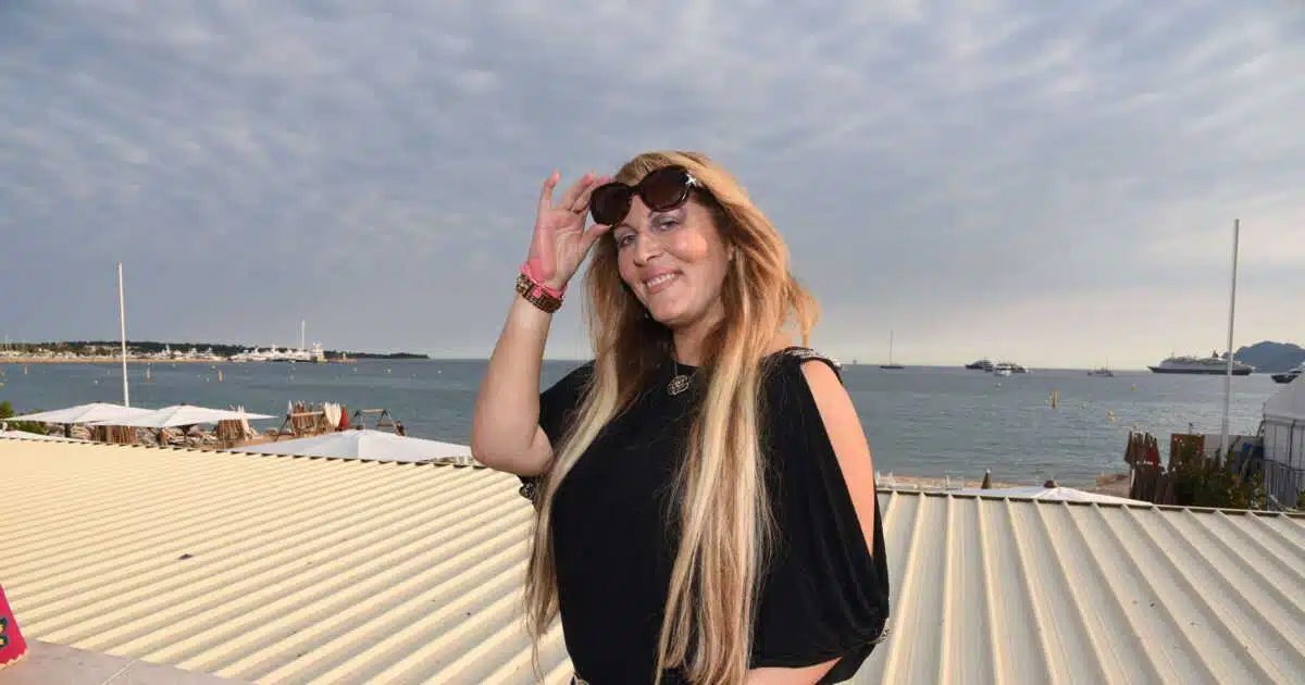 Loana souriant avec des lunettes de soleil devant la mer à Cannes