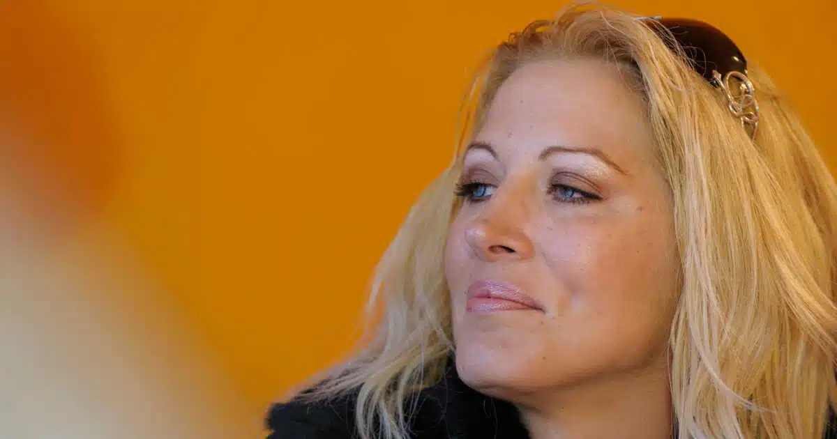 Loana en gros plan, regard pensif, cheveux blonds, fond orange