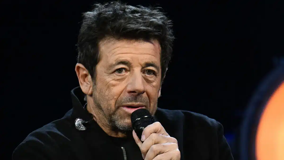 Patrick Bruel tenant un microphone lors d'une prise de parole publique