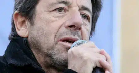 Patrick Bruel tenant un microphone, visage en gros plan