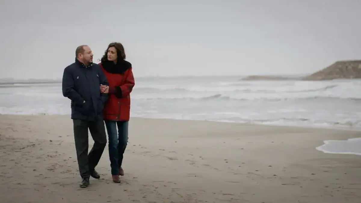 Un couple se promène sur une plage venteuse en hiver dans la série Un si grand soleil