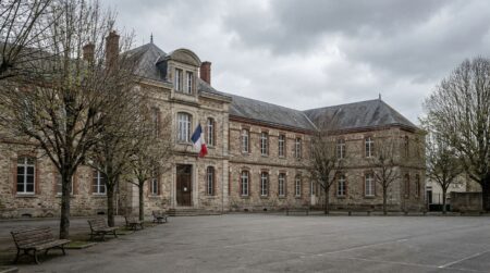 Cour vide d'un lycée français sous un ciel couvert