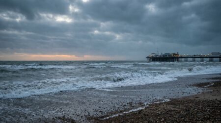 Plage de galets de Brighton à l'aube avec mer agitée