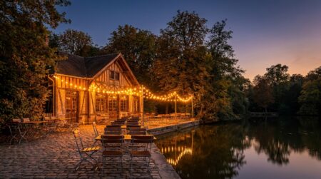 Chalet illuminé au bord d'un lac dans un parc boisé
