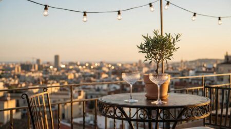 Terrasse au crépuscule avec verres vides et guirlandes lumineuses