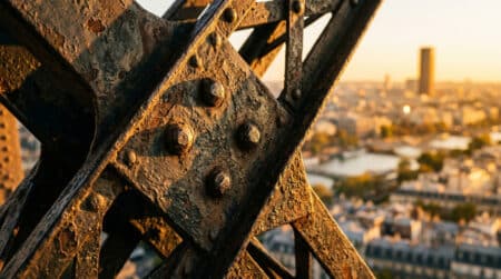 Gros plan sur les rivets en fer de la tour Eiffel au coucher du soleil