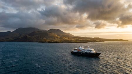 Navire de croisière ancré près d'une île volcanique isolée