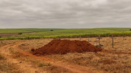 Tombe fraîchement creusée dans un paysage rural africain