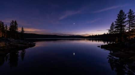 Ciel nocturne étoilé avec reflet sur un lac sombre