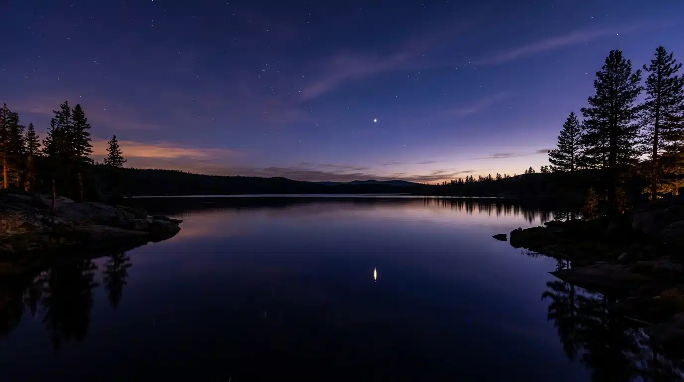 Ciel nocturne étoilé avec reflet sur un lac sombre