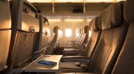 Cabine d'avion vide avec smartphone affichant des réseaux Wi-Fi