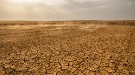 Sol craquelé et sec sous un ciel brumeux de canicule