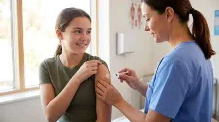 Adolescente souriante recevant un vaccin dans une infirmerie scolaire