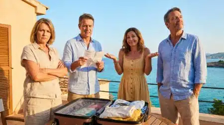 Groupe d'amis frustrés autour d'une valise sur une terrasse ensoleillée