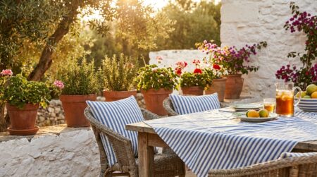 Terrasse méditerranéenne avec coussins et nappe à rayures bleues et blanches