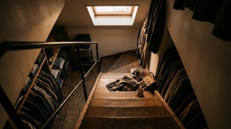 Escalier étroit dans un magasin de vêtements avec affaires éparpillées