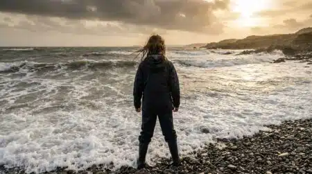 Adolescente debout face aux vagues sur une plage galloise