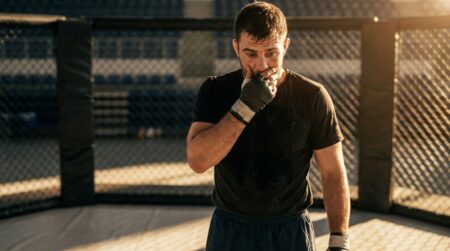 Combattant MMA seul dans un octogone vide, visage grave
