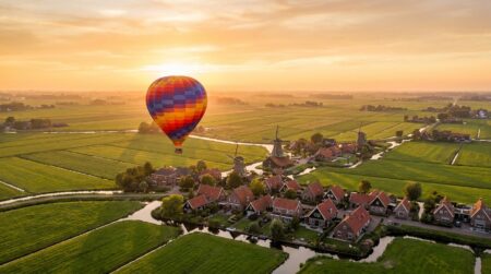 Montgolfière colorée survolant une ville néerlandaise au coucher du soleil