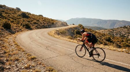 Cycliste solitaire sur une route de montagne en pleine chaleur