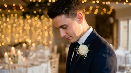 Gros plan d'un jeune marié en costume sombre avec boutonnière