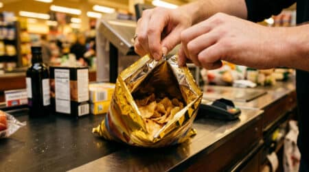 Personne ouvrant un paquet de chips Lay's rempli d'air