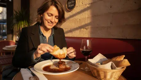 Personne sauçant son assiette avec du pain dans un bistrot