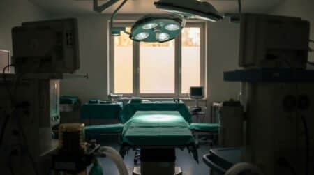 Bloc opératoire vide avec table chirurgicale et lampe scialytique
