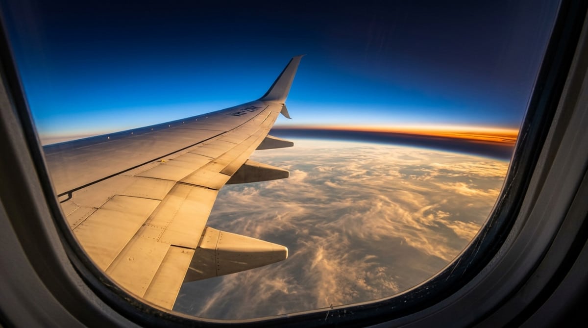 Vue depuis un hublot d'avion à haute altitude au coucher du soleil