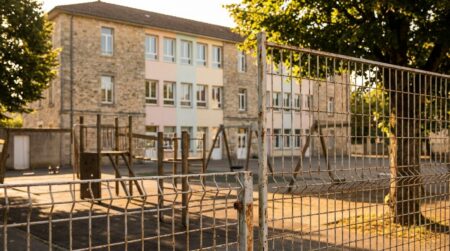 Façade colorée d'une école maternelle française avec grille